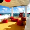Red bean bags on the shaded upper deck of a catamaran looking out to open sea