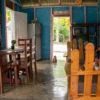 Inside a traditional Dominican home The bright blue front room of a rural Dominican home, with wooden rocking chairs and a family dog