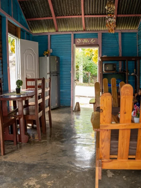 Inside a traditional Dominican home The bright blue front room of a rural Dominican home, with wooden rocking chairs and a family dog
