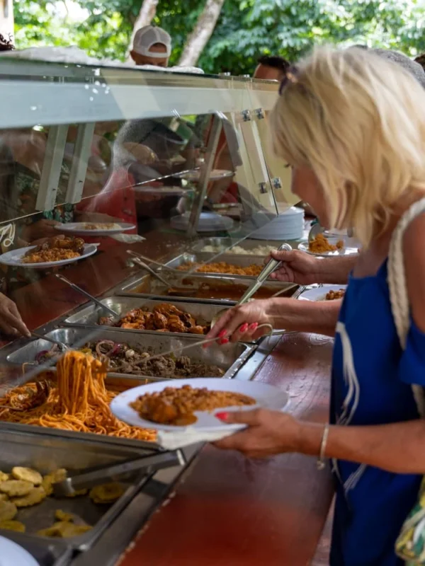 Typical Dominican lunch A guest serving herself rice, stewed chicken and plantain from the buffet at the mountain ranch