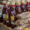 Mama Juana and local products Bottles of Mama Juana with woven straw caps beside bagged bark and root mixes for sale