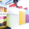 A bottle of Barcelo rum stands beside jugs of juice mixers at the boat drinks station