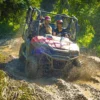 A buggy powers head-on through a muddy track throwing up a wall of spray