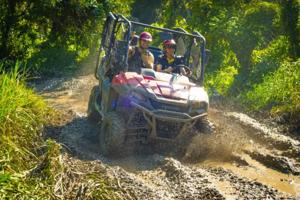 A buggy powers head-on through a muddy track throwing up a wall of spray