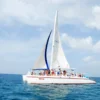 The catamaran Neya under full sail The catamaran Neya under full sail on deep blue open water with guests gathered on the foredeck