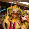 A carnival performer in a horned Diablo Cojuelo mask and sequinned costume leads the afternoon show