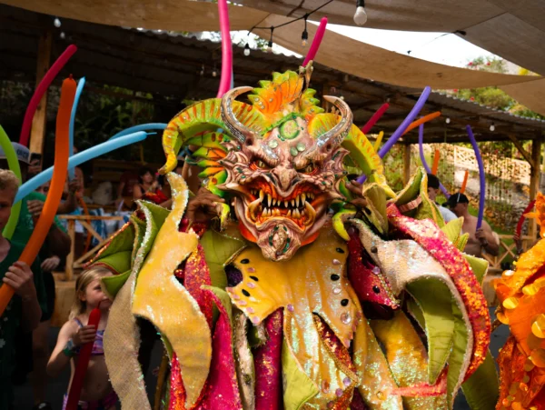 A carnival performer in a horned Diablo Cojuelo mask and sequinned costume leads the afternoon show