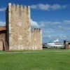The crenellated Tower of Homage at the Fortaleza Ozama seen across a wide green lawn